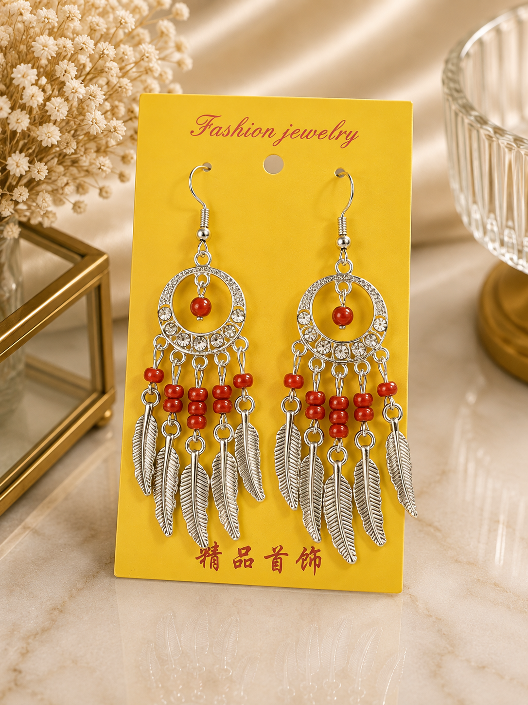 Aretes de fantasía estilo atrapasueños con cuentas rojas y plumas